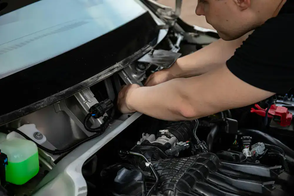 Technician performing mobile windscreen repair on a vehicle