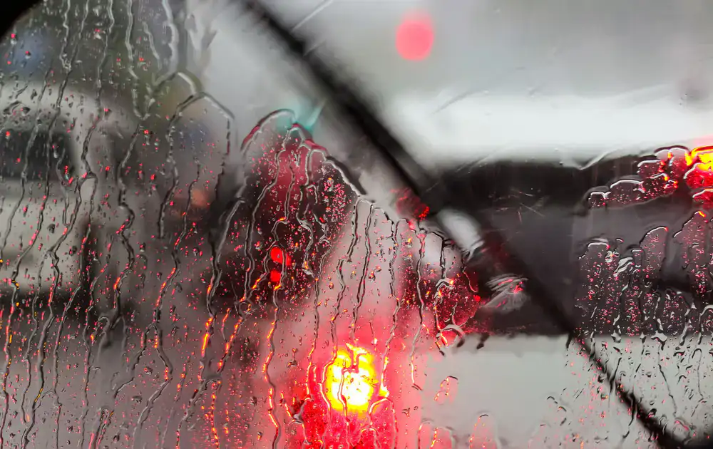 Technician fitting a new windscreen to a car